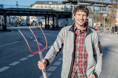 Landwirt mit Forke in der Hand vor U-Bahn