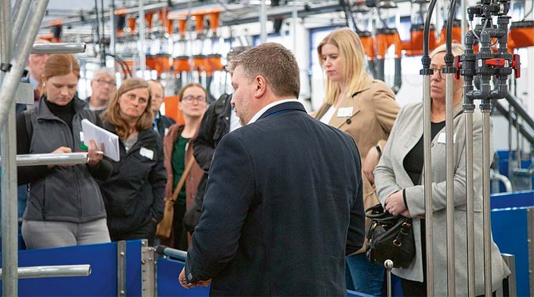 Big Dutchman system manager Dennis Engelking guiding visitors through the barn, illustrating how the technology works.