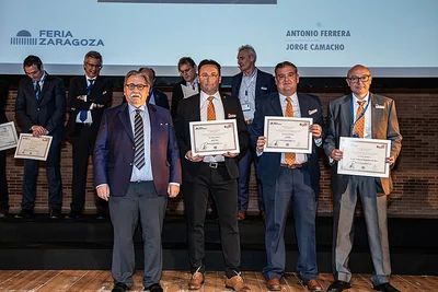 Entrega de premios con cuatro hombres y diplomas en primera fila