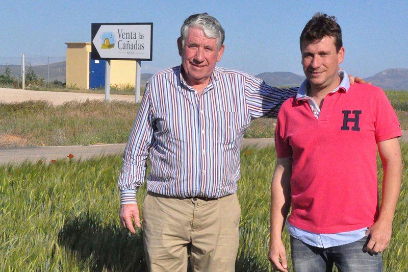 Padre e hijo ante el cartel de la empresa de la familia Esteban