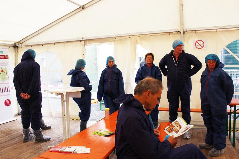 Besucher in Schutzkleidung