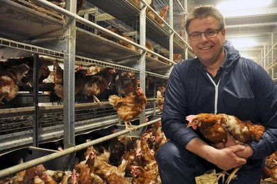 Geflügelhalter Honerkamp neben seiner Voliere für die Bodenhaltung Geflügelhalter Honerkamp neben seiner Voliere für die Bodenhaltung