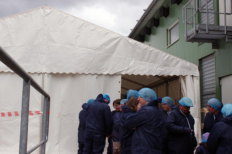 Besucher in Schutzkleidung