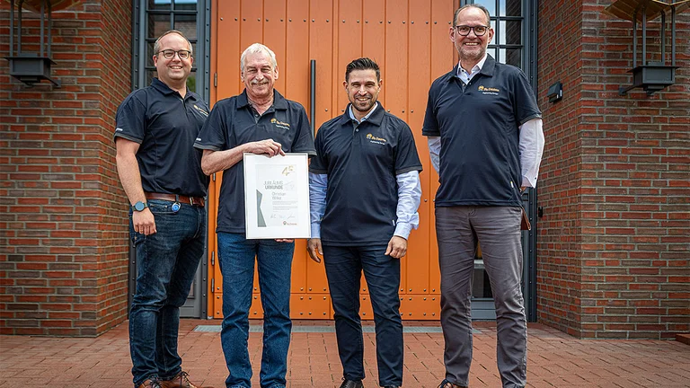 45 Jahre im Dienst der Digitalisierung! Christian Wilke (zweiter von links) wurde von CFO Erkul Basaran (zweiter von rechts) für seine 45-jährige Betriebszugehörigkeit bei Big Dutchman geehrt. Gruppenbild mit vier Männern