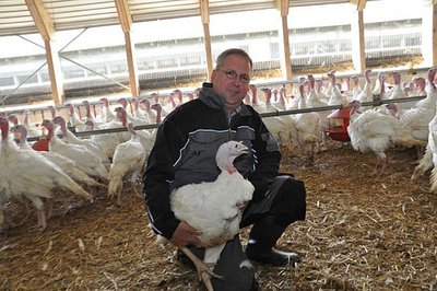 Putenhaltung: Landwirt mit Pute im Arm